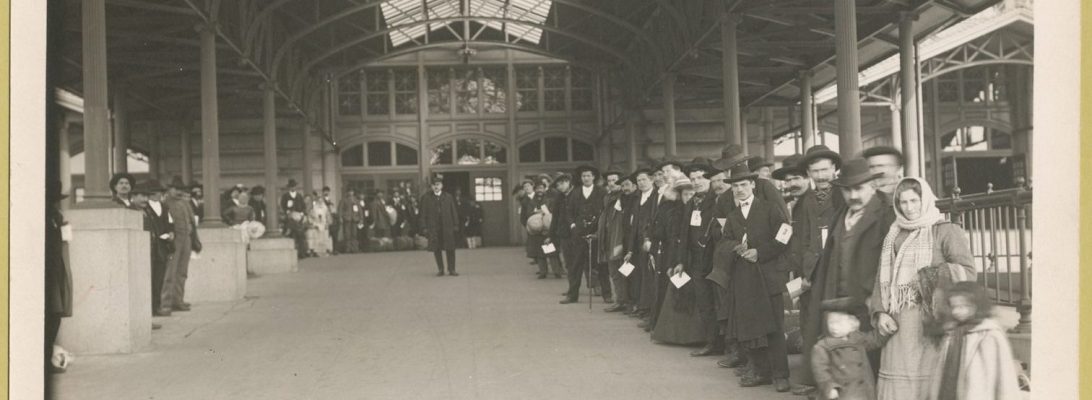 Old photo showing immigrants lined up to leave the hall at Ellis Island
